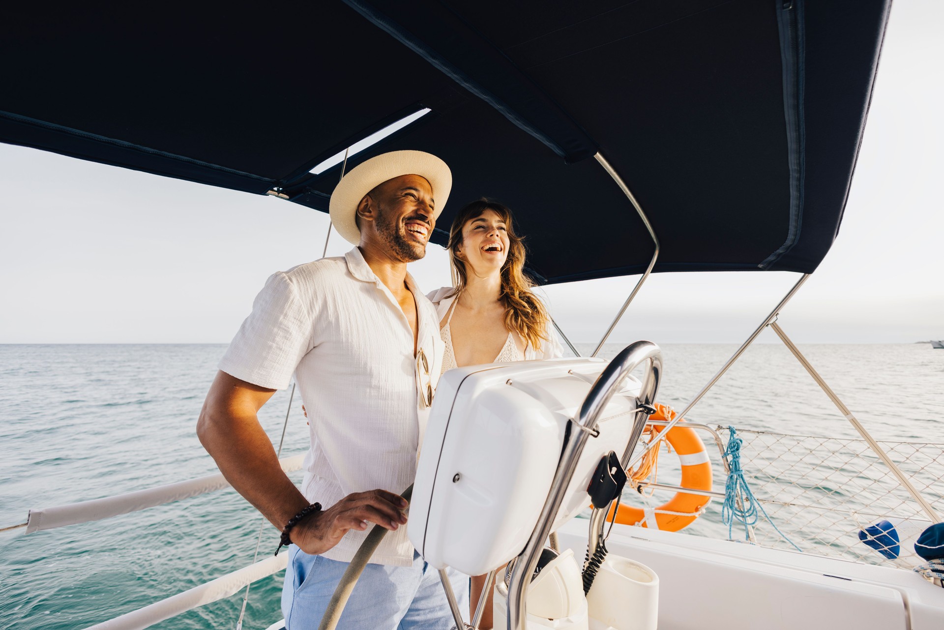 Happy couple enjoying leisure time sailing on a yacht at sea